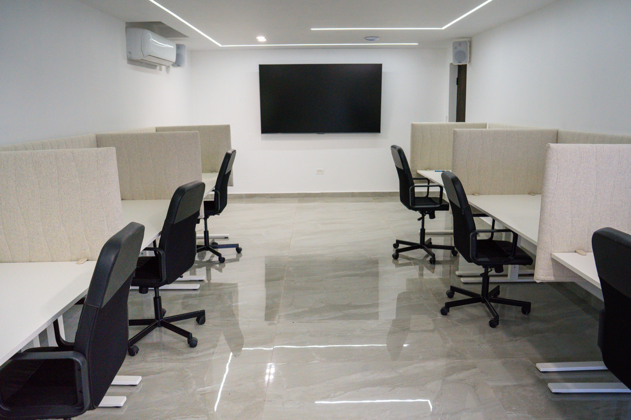 Interior de ELEMENTS con seis estaciones de trabajo y pantalla central