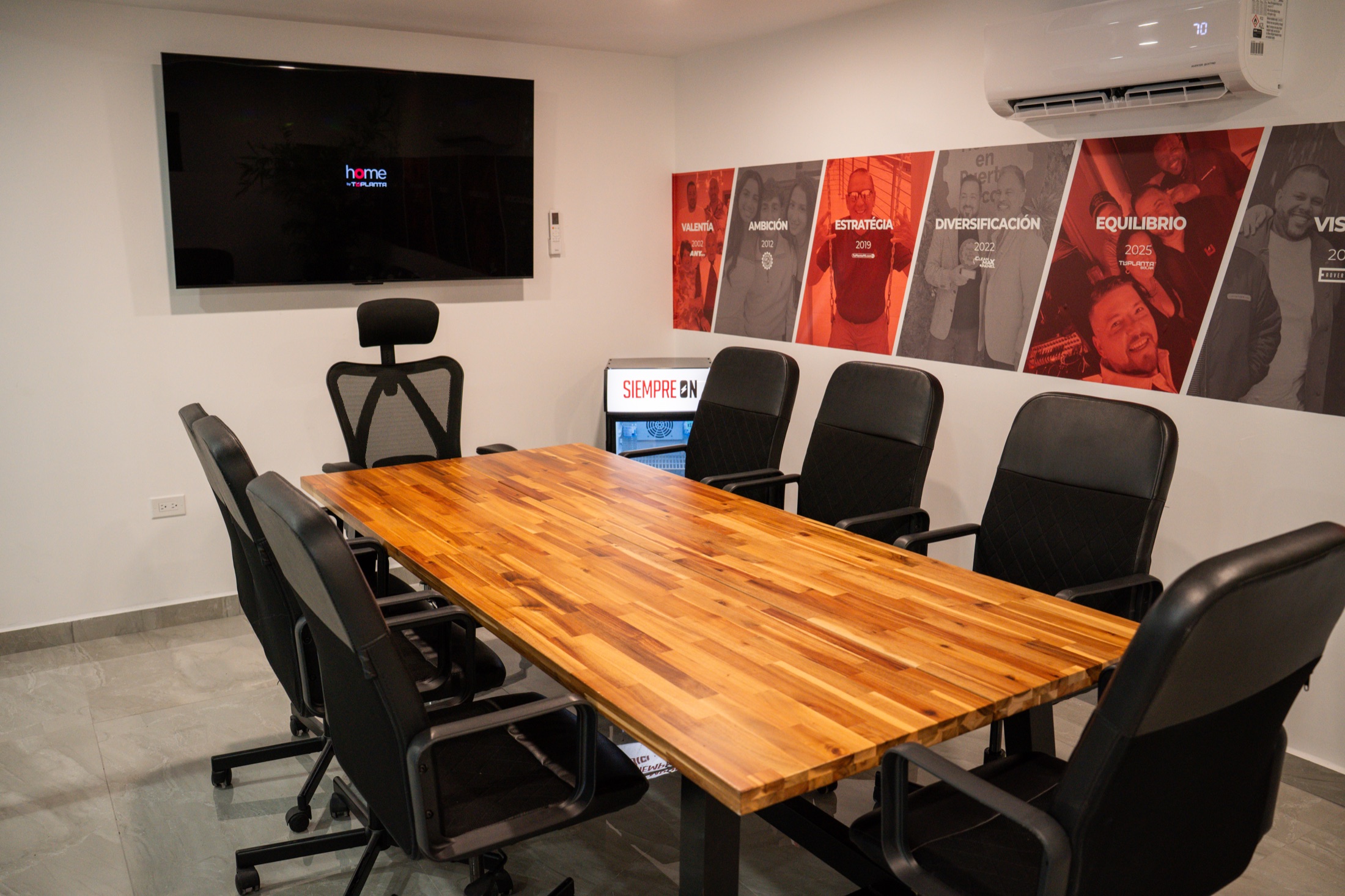 Interior de NOVA con mesa de conferencia, sillas y pantalla