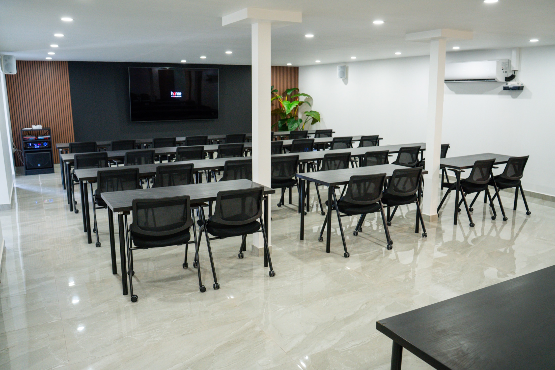 Interior de ZEN preparado como auditorio con pantalla y cuarenta y cinco asientos